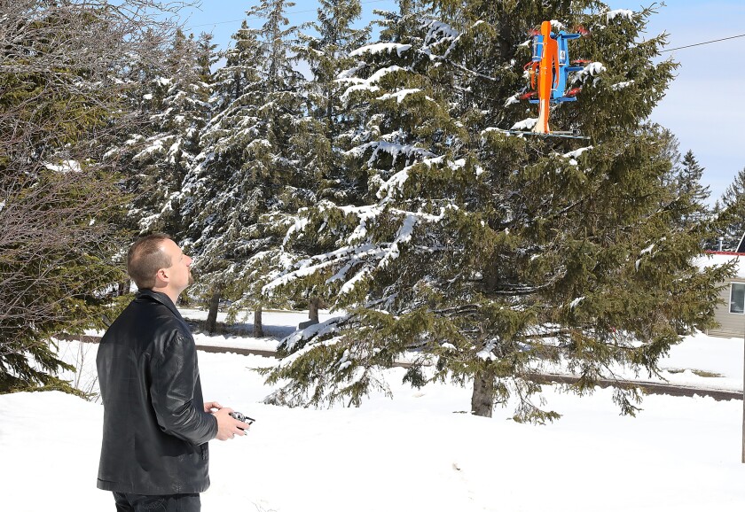 Daniel Gant, founder of Ascend Dynamics, LLC, flies a smaller prototype of his SkyPak, a propeller-driven jetpack, outside of his workshop