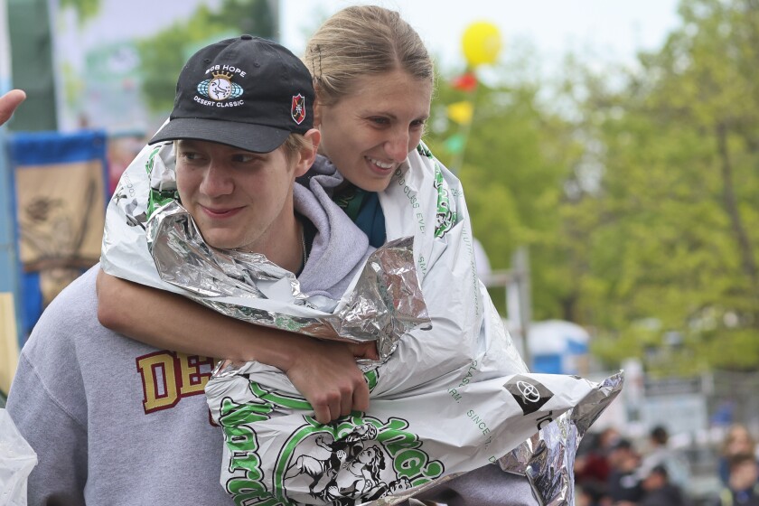 Athletes running and celebrating at the finish line area of Grandma's Marathon