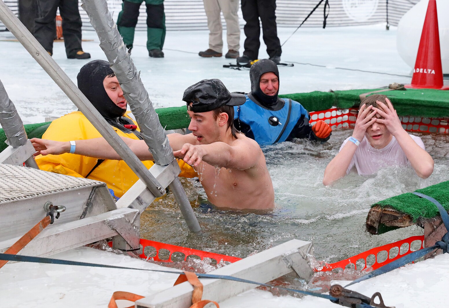 People jump into the water during the Polar Plunge event on Pelican Lake.