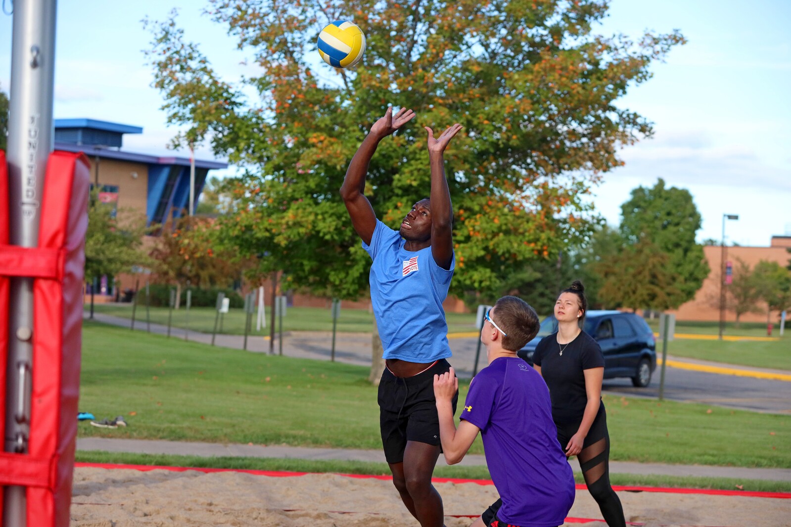 Volleyball players compete outside on the sand volleyball courts at CLC.