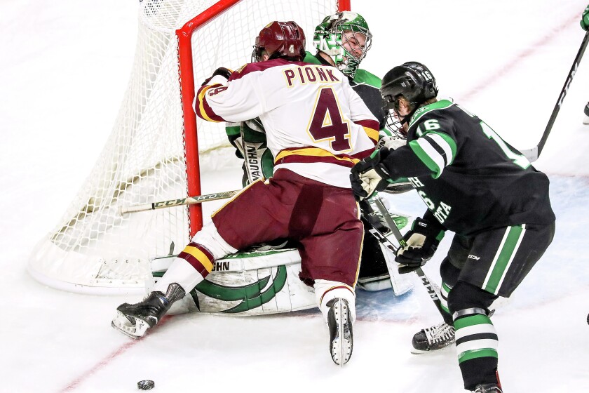 Clint Austin / caustin@duluthnews.com Minnesota Duluth defenseman Neal Pionk (4) skates into North Dakota goaltender Cam Johnson during the NCHC championship game Saturday night at Target Center in Minneapolis. Pionk was given a five-minute charging penalty.