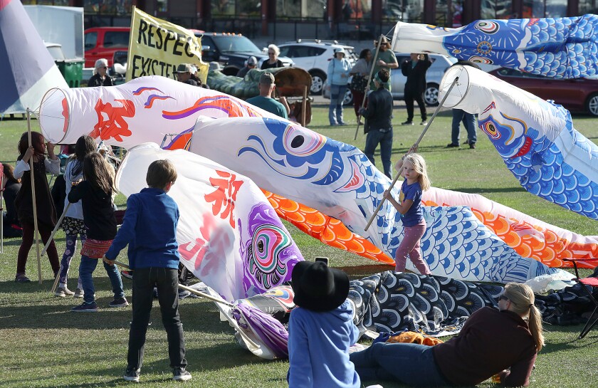 Children play with fish puppets during the Water is Life Festival