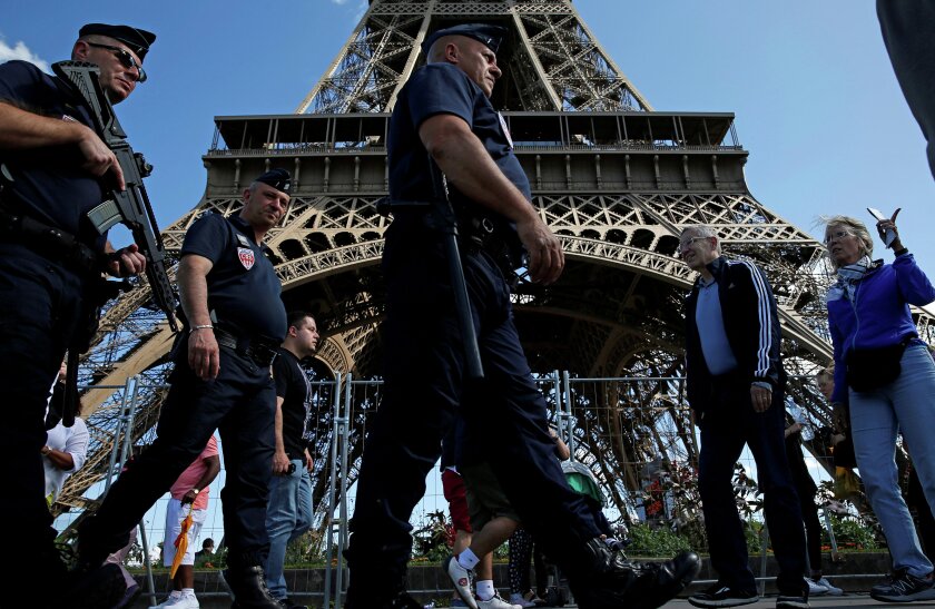 French CRS policemen patrol as tourists walk past in front of the Eiffel Tower in Paris, France August 20, 2016. REUTERS/Pascal Rossignol/File Photo