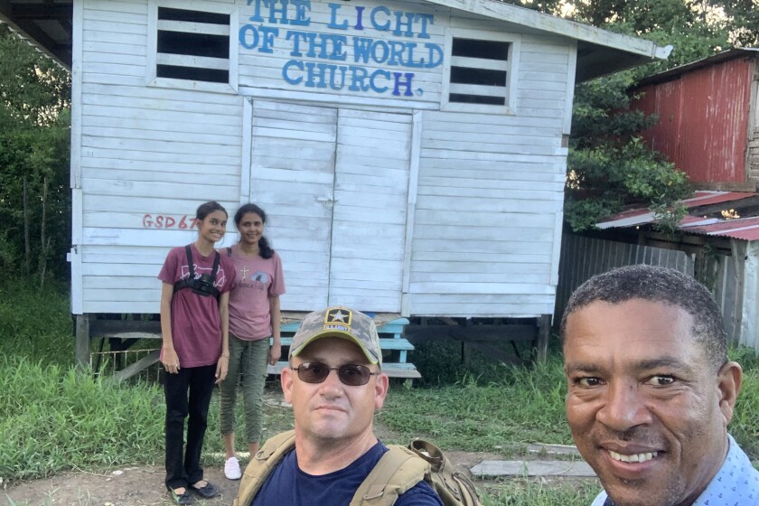 Guyana_Joe and Pastor Ray Garrett in front of one of three churches without electricity and water on the sea dam that the Allens supported_ in the background is Marcia, right, and her cousin Hannah..jpeg