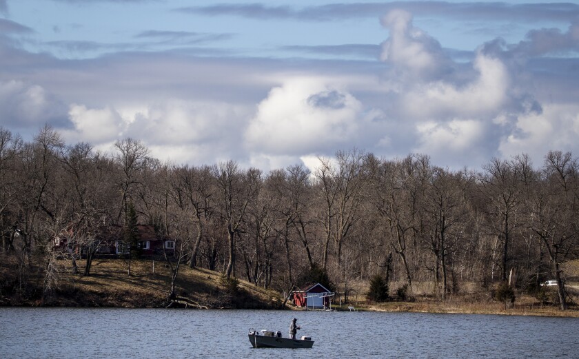 A fisherman casts his line into the open waters of Nest Lake during the early morning hours of Tuesday, May 3, 2022, near New London.