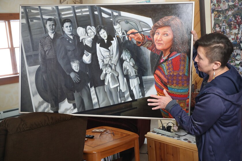 Woman holds painting of her painting a painting.