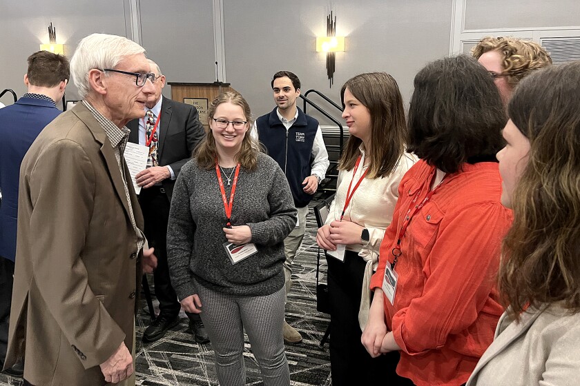 Wisconsin governor, left, talks to high school students.