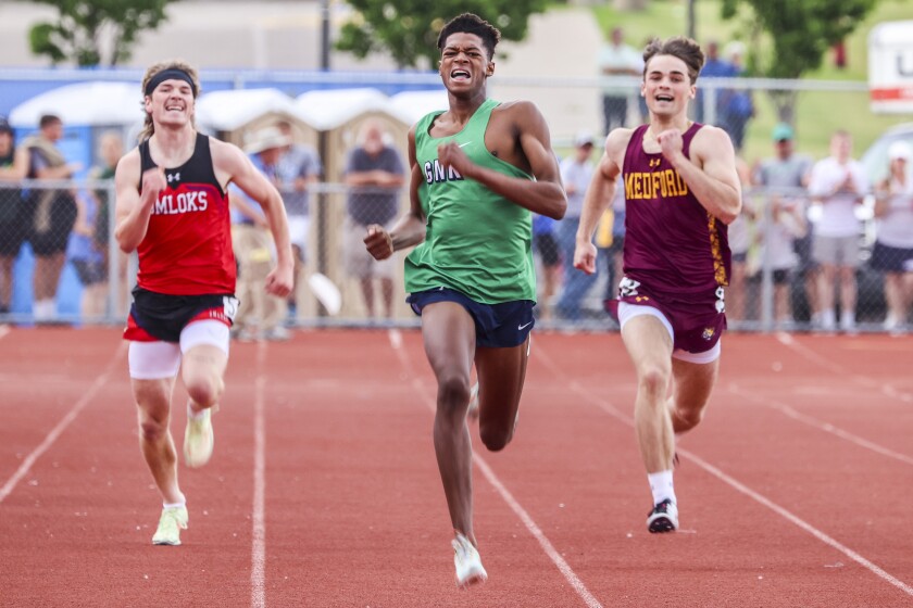Athletes compete in track and field events at outdoor stadium