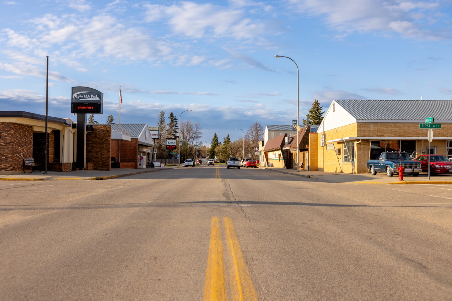 A small downtown features mismatched, one-story buildings along a two-way street.
