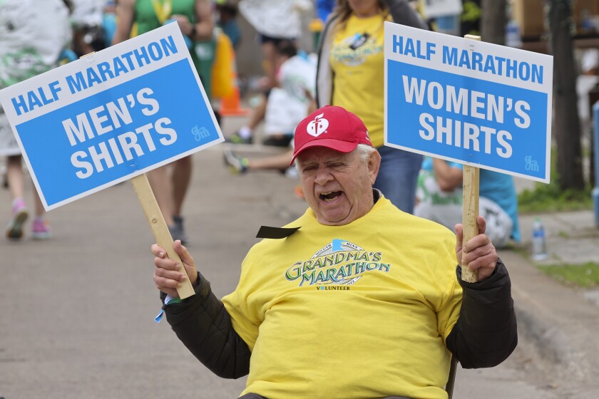 Athletes running and celebrating at the finish line area of Grandma's Marathon