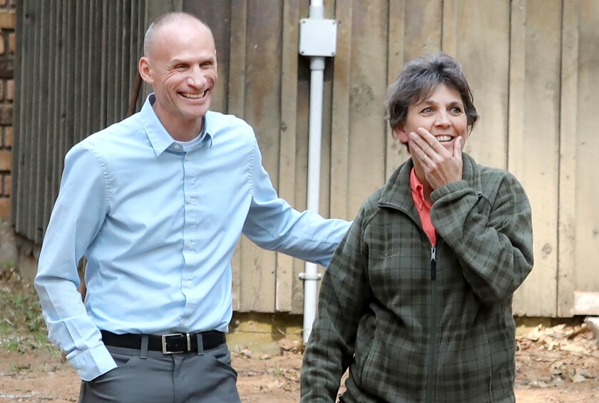 Superior High School science teacher Lori Danz, right, walks in shock with fellow teacher, Andy Wolfe, as she sees the large crowd gathered to meet her at the Superior School Forest
