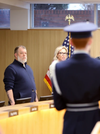 Fargo School Board member Seth Holden, left, declines to participate in the Pledge of Allegiance with the Air Force Junior Reserve Officers Training Corps Color Guard at the Tuesday, April 12, 2022, meeting. The board will no longer recite the verse after it rescinded the motion on Tuesday, Aug. 9, voting in favor of removing it.Michael Vosburg/The Forum