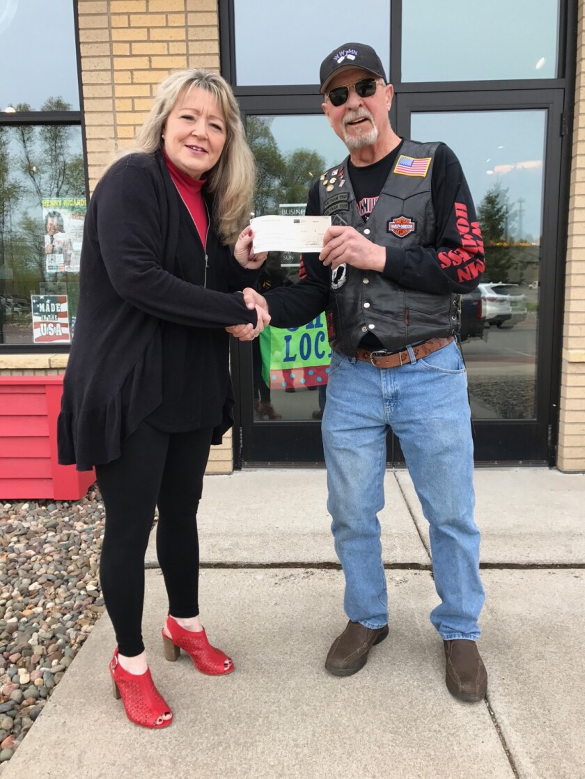 Doreen Gallaway (left), president of the Crosslake/Ideal Lions Club, presents a $12,500 check to Stephen Eisenreich of Homeless and Wounded Warriors of Minnesota. The check is the largest single donation the organization has ever received. Submitted photo