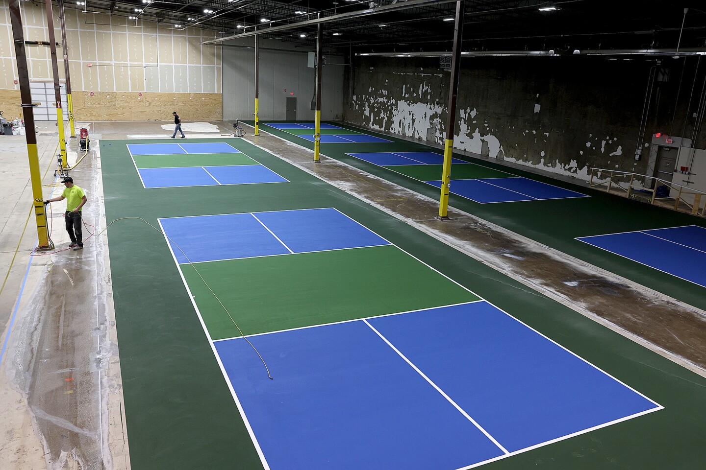 People work on the pickleball courts.
