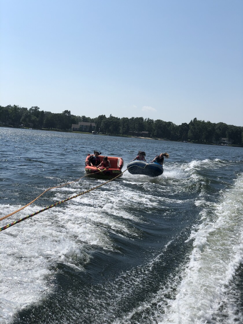 Children go tubing on a lake.