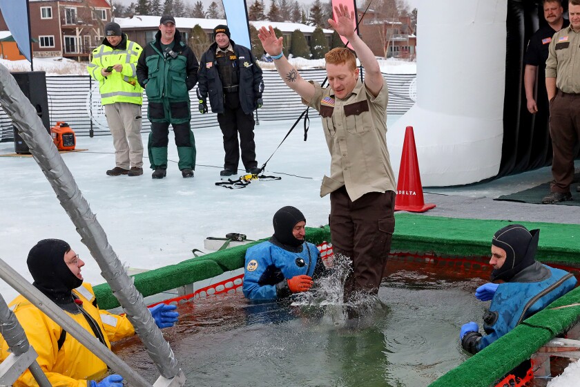 People jump into the water during the Polar Plunge event on Pelican Lake.