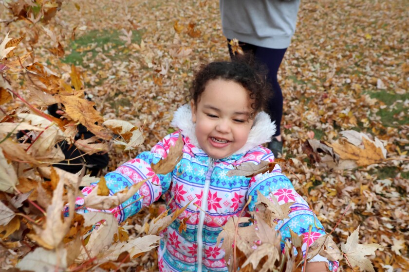 Aaliyah Northington hází náruč podzimního listí v sobotu 25. října 2025 v Aitkinu.