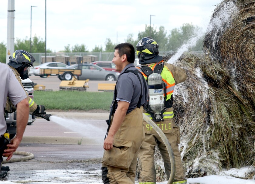 Worthington firefighters extinguish a hot spot in a load of round bales on Oxford Street Tuesday afternoon.