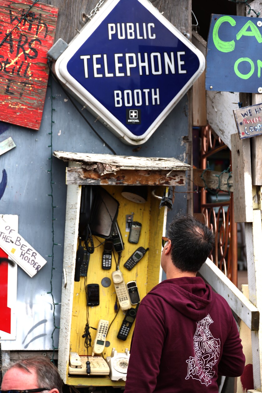 Man looks at old phones displayed on wall