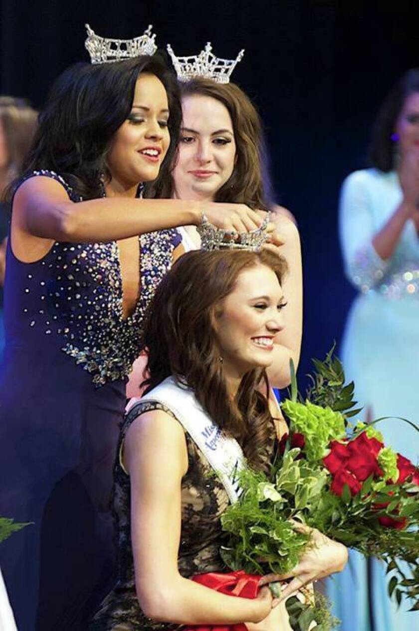 Rebecca Yeh, Nisswa, Miss Minnesota 2013, secures the tiara on Savannah Cole's head at the Miss Minnesota Scholarship Pageant in Eden Prairie Saturday.