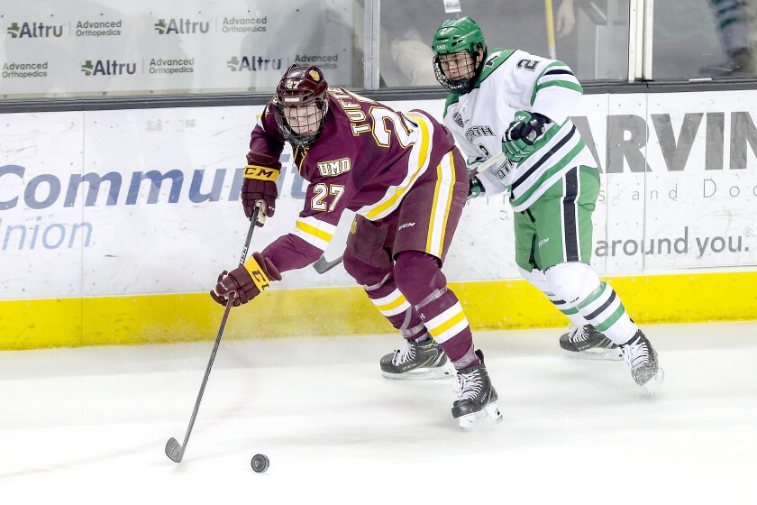 t022219 --- Clint Austin --- 022419.S.UMDMPUX.C06 --- Forward Riley Tufte (27) of the Minnesota Duluth Bulldogs controls the puck near defenseman Gabe Bast (2) of the North Dakota Fighting Hawks during Saturday's game at Ralph Engelstad Arena in Grand Forks, ND. --- Clint Austin / caustin@duluthnews.com