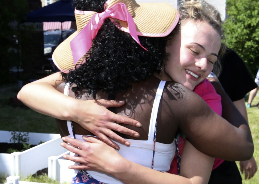 Two women hug.