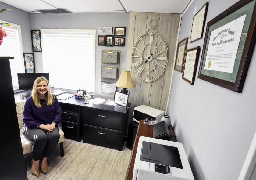 Attorney Ashley Anson is seen in the reflection of a mirror in her office along with photos of her with South Dakota Chief Justice David E. Gilbertson in Wessington Springs. Anson runs her own general practice law firm back in her hometown. Matt Gade / Forum News Service