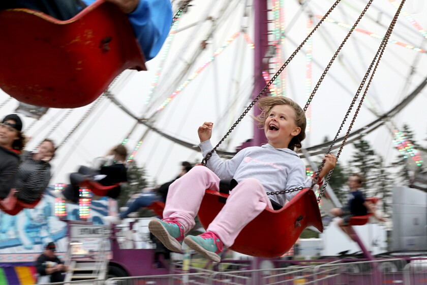 Aira Anderson, 5, laughs as she whirls around on the Swinger at the Head of the Lakes Fairgrounds