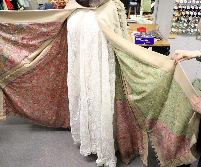 Lisa Blade, left, and Peg Ferguson open the jacket to show the inner lining of the costume worn on Broadway by Angela Lansbury