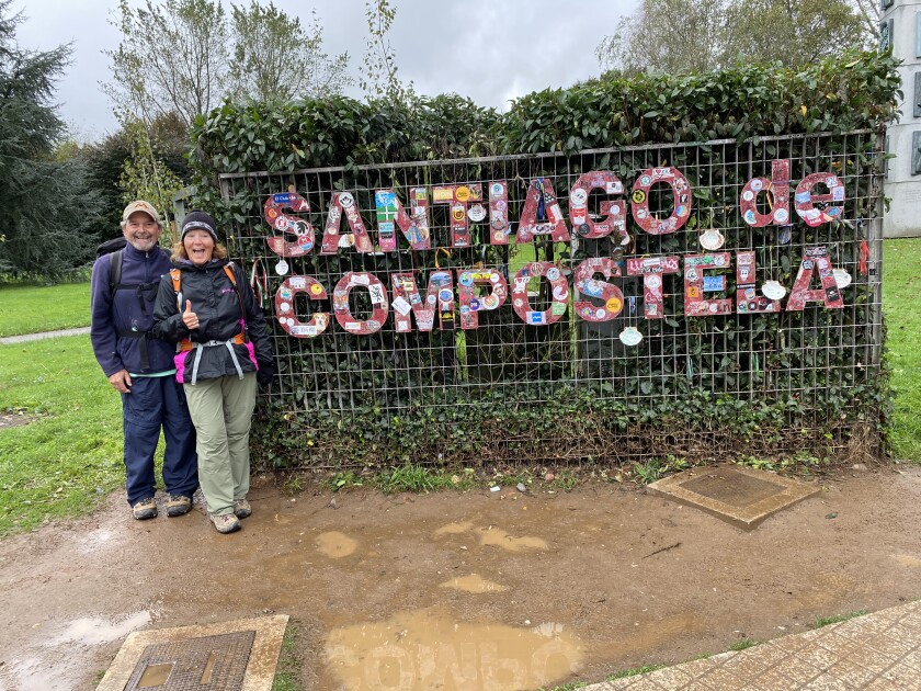 Tom y Barb Aggerter posan frente a un cartel en Santiago de Compostela al final de una caminata de 502 millas por España en El Camino de Santiago. 