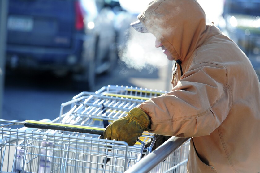 Working in sub-zero weather, Joe Borg pushes shopping carts out of their corral at Super 1 Foods in Baxter Monday morning. Brainerd Dispatch/Steve Kohls