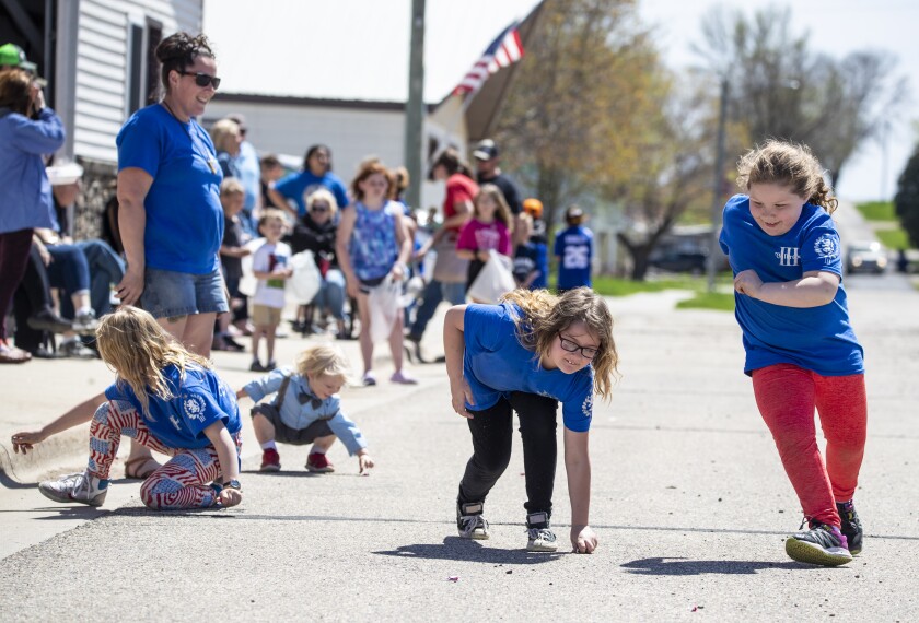 Willow Hoffman, 6, from right, Lorelei Hoffman, 9, and Aryanna Hoffman, 7, pick up candy on the sidewalk of Main Street during the 16th annual "A Taste of Syttende Mai," Saturday, May 14, 2022, in Milan.