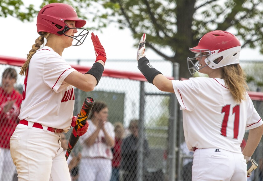 Willmar freshman Madison Norsten, at left, gives a high five to junior Cadence Parker during a Section 8AAA playoff game against Sauk Rapids in Willmar on Tuesday, May 24, 2022.