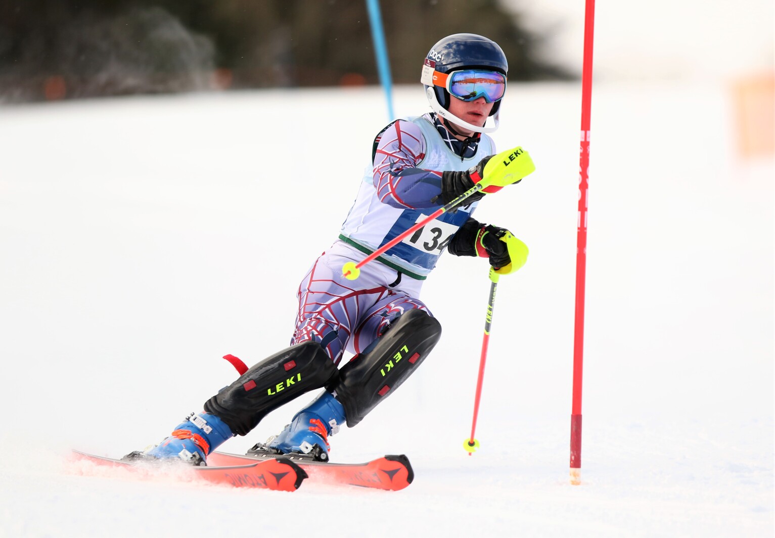 A downhill skier moves around a gate.