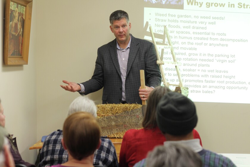 In addition to presenting his popular straw bale gardening method to a full room at the Pine River Community Library, Author Joel Karsten also introduced his audience to a new trick for compressing used straw bales into new, even better nutrient rich bales. Photo by Travis Grimler