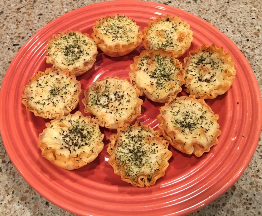 plate of pie-like pastries filled with cheese and sprinkled with herbs