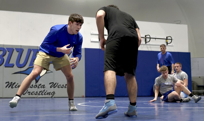 Minnesota West Blue Jays Damon Ashworth (on left) spars with teammate Ryan Fierro as (right rear to front) head coach Randy Baker, assistant coach Cameron Henning and Jacob Vogel watch from the mat.