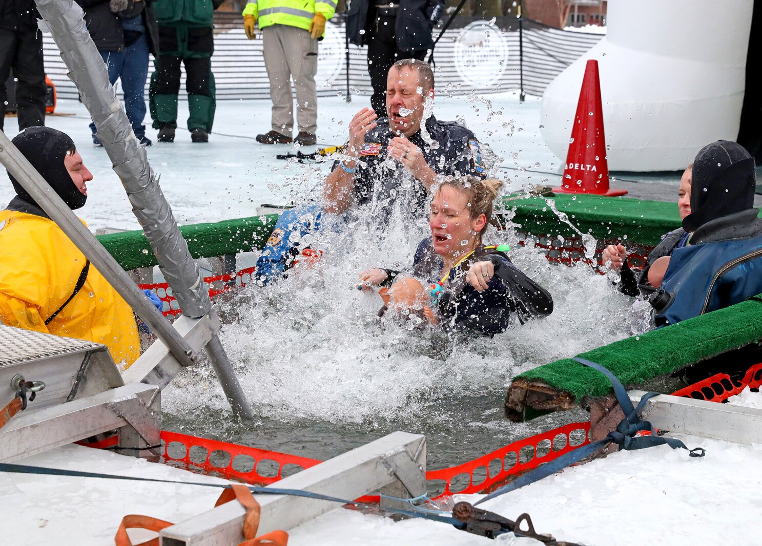 People jump into the water during the Polar Plunge event on Pelican Lake.