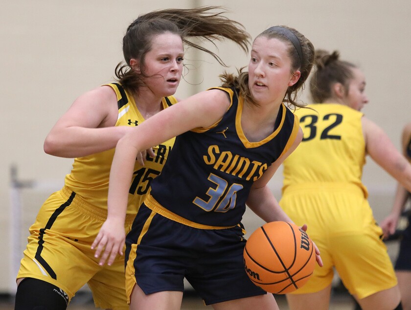St. Scholastica’s Katie Vaske (30) tries to drive in on UW-Superior’s Mady Sanders (15)