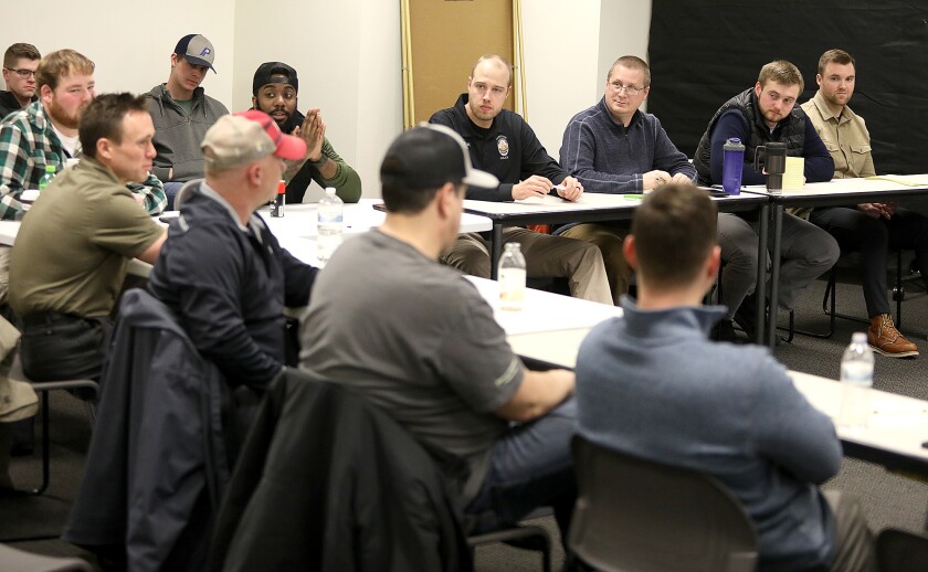 Members of the Superior Police Department discuss some things they learned running through scenarios at the Active Bystandership for Law Enforcement (ABLE) project training