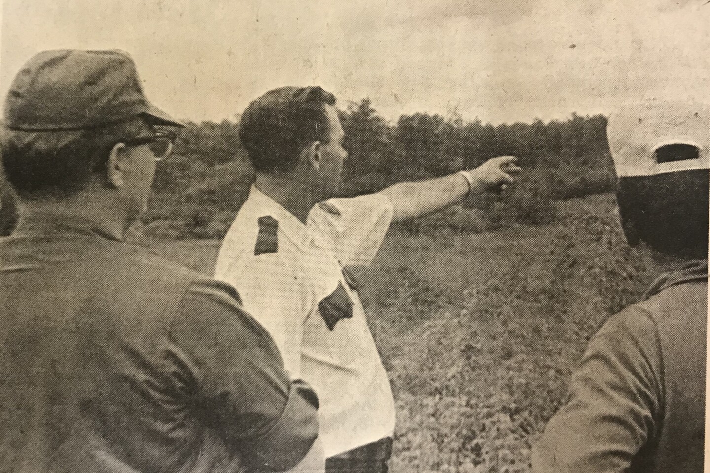 Becker County Sheriff Jerry Townsend of Detroit Lakes points to an area where the search was conducted for Milda McQuillan to Capt. Arthur Yliniemi, left, and Duane Winter, right, of the National Guard. Capt. Yliniemi coordinated National Guard activities in the search in 1975. File Photo