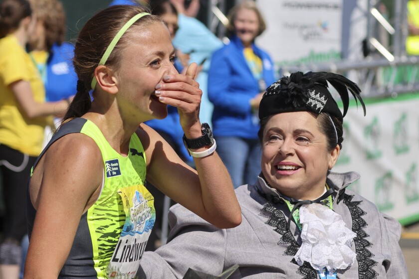 Athletes running and celebrating at the finish line area of Grandma's Marathon