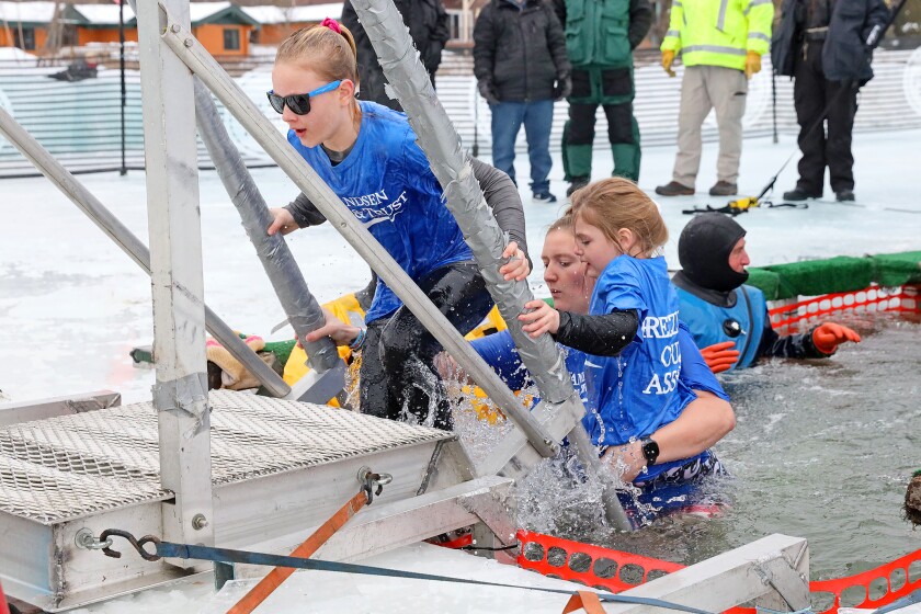 People jump into the water during the Polar Plunge event on Pelican Lake.