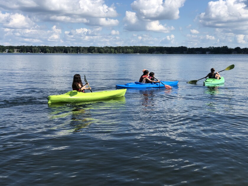 People are kayaking on a lake.