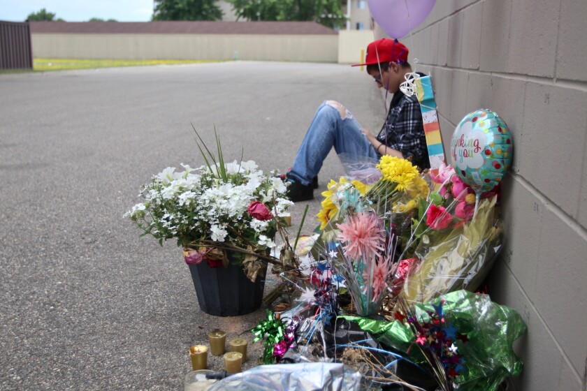 Daisy 'Jupiter' Paulsen's older sister, Phoenix, sitting beside the pop up memorial outside of Party City on 13th Avenue on Friday, June 25, 2021.jpg