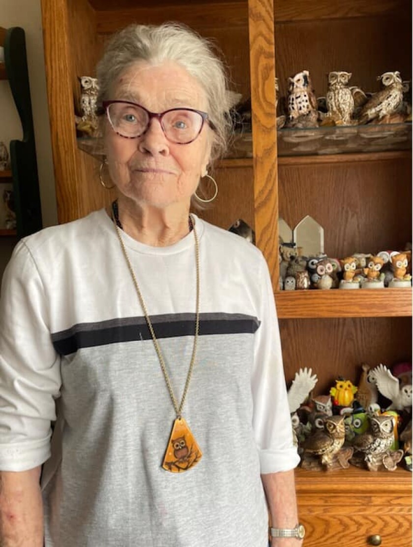 A nursing home resident wears a gift she received from her pen pal.