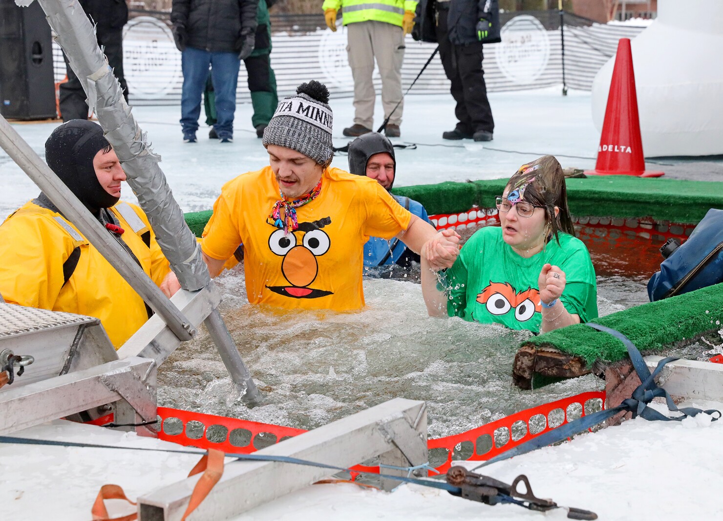 People jump into the water during the Polar Plunge event on Pelican Lake.