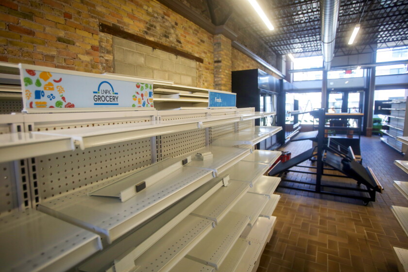 Shelves and aisles inside of a grocery store that's preparing to open.