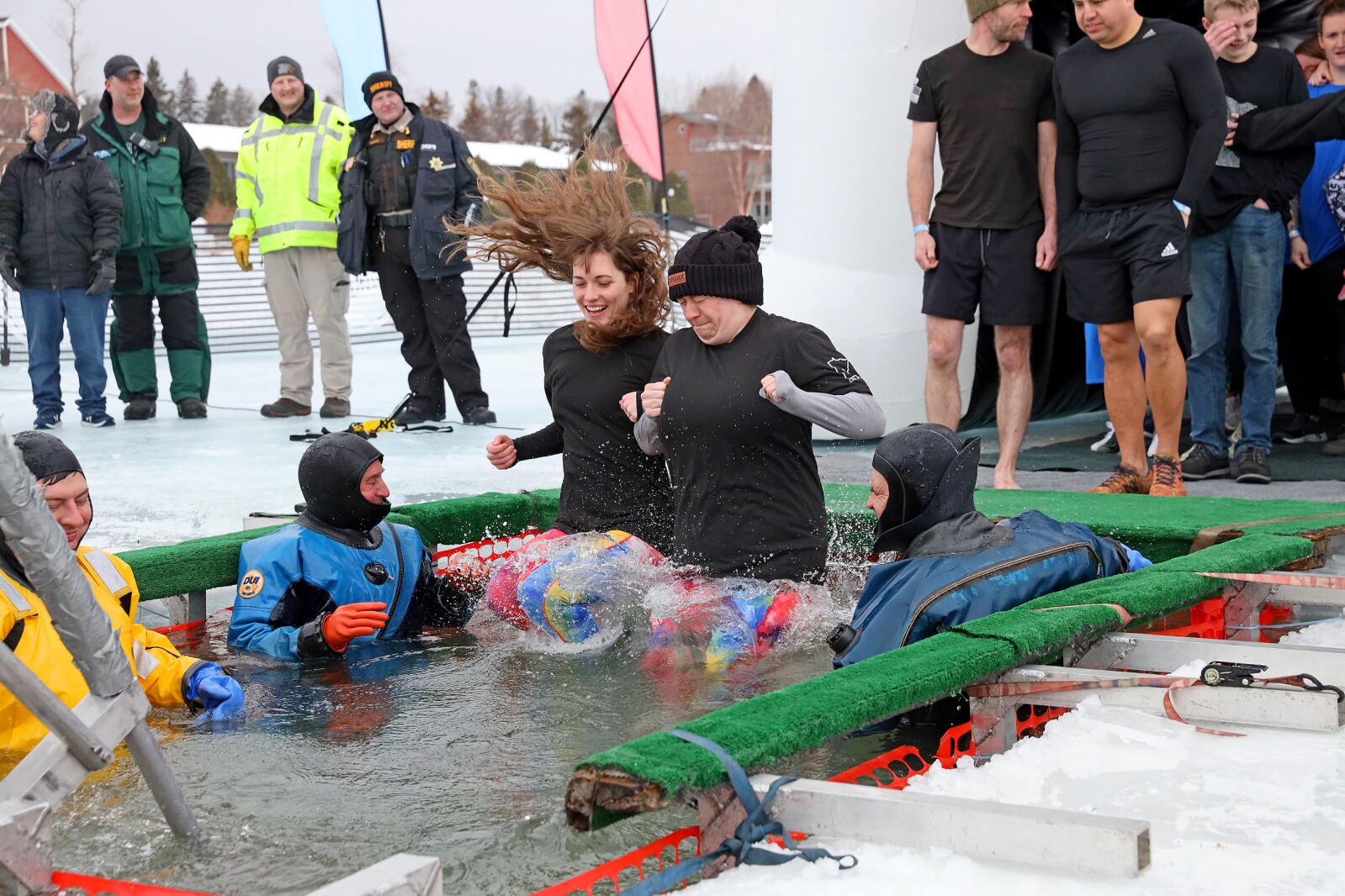 People jump into the water during the Polar Plunge event on Pelican Lake.