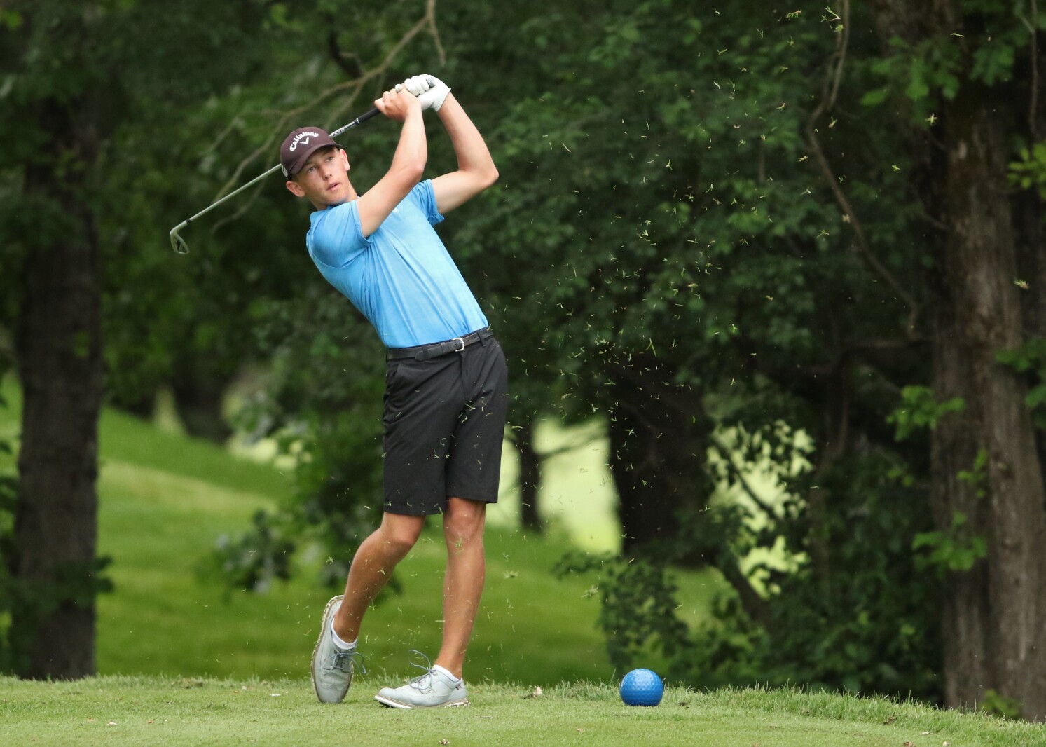 Golfer hits the ball.
